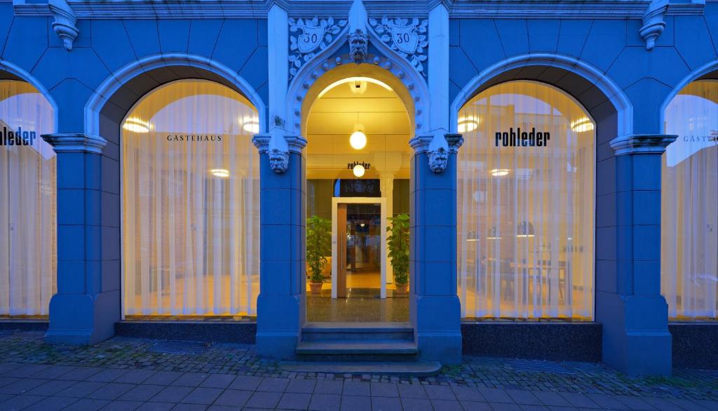 ein blaues Gebäude mit gewölbten Fenstern und einer Tür in der Unterkunft Gästehaus Rohleder in Velbert