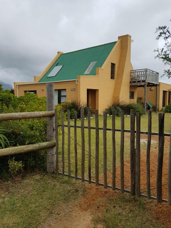 una casa con una valla delante en Pelagonia, en Bettyʼs Bay