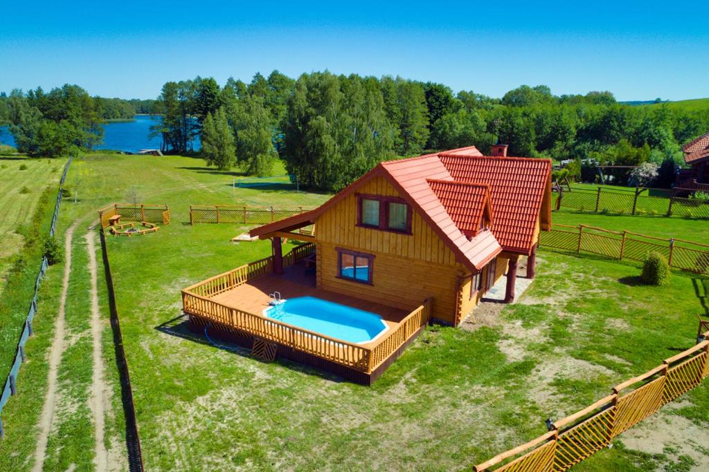 a small house with a swimming pool in the yard at Rezydencja Limajno in Dobre Miasto