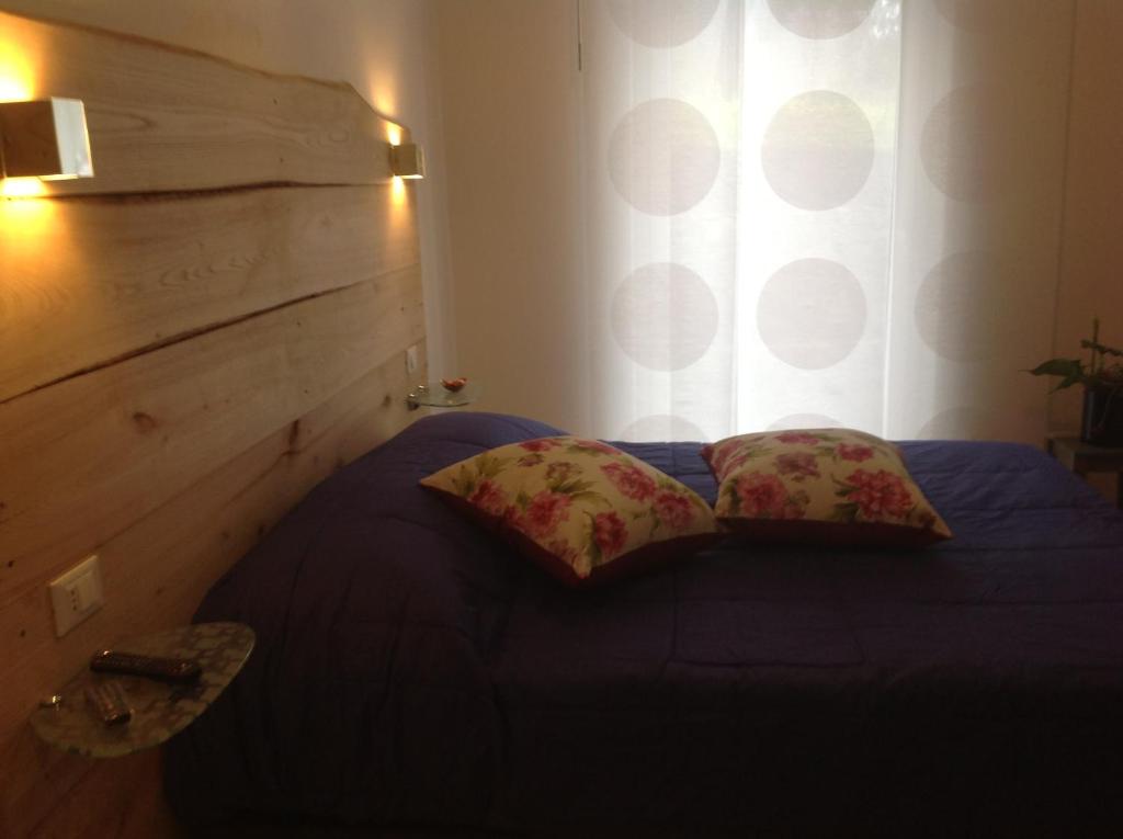 a bedroom with a bed with two pillows and a window at Corte Del Gallo in Corniglia