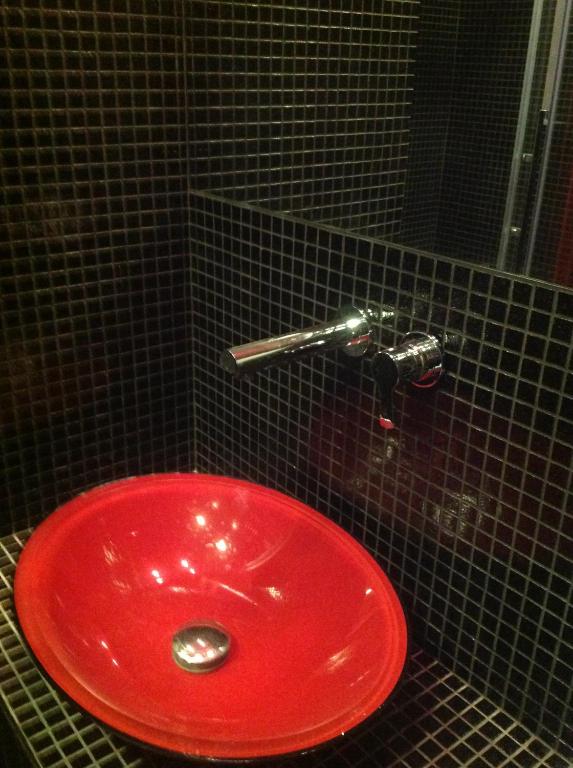 a red sink in a black tiled bathroom at Corte Del Gallo in Corniglia