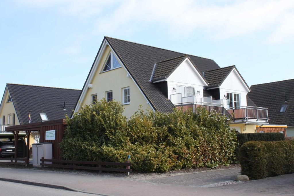 a row of houses with black roofs on a street at Fewo Sanddorn_BOBE in Ostseebad Karlshagen