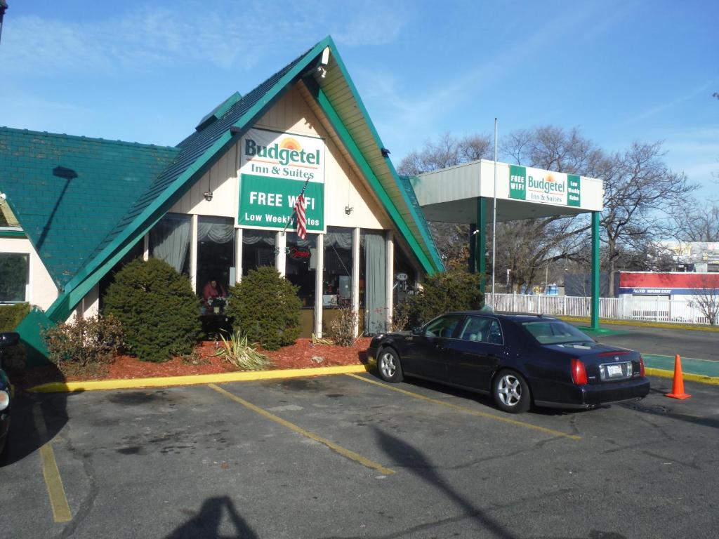 a car parked in a parking lot in front of a store at Budgetel Inn & Suites Hotel in Grand Rapids