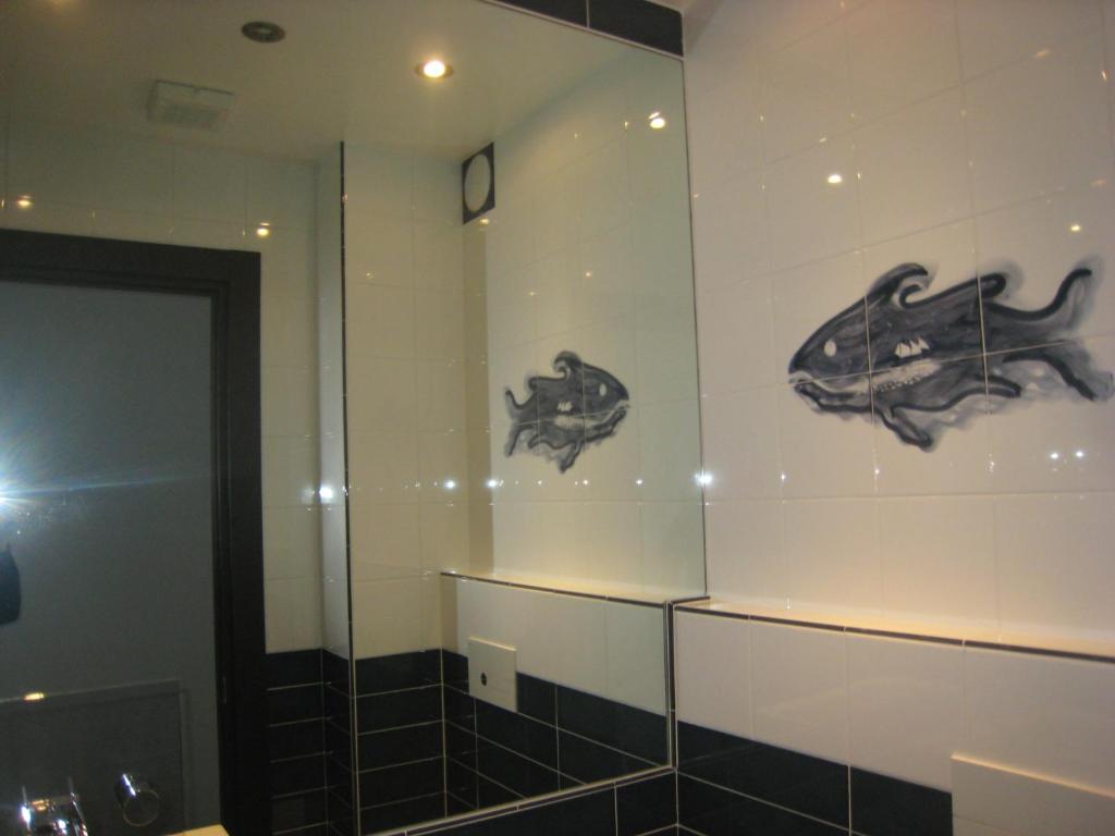 a bathroom with two pictures of animals on the wall at Corte Del Gallo in Corniglia
