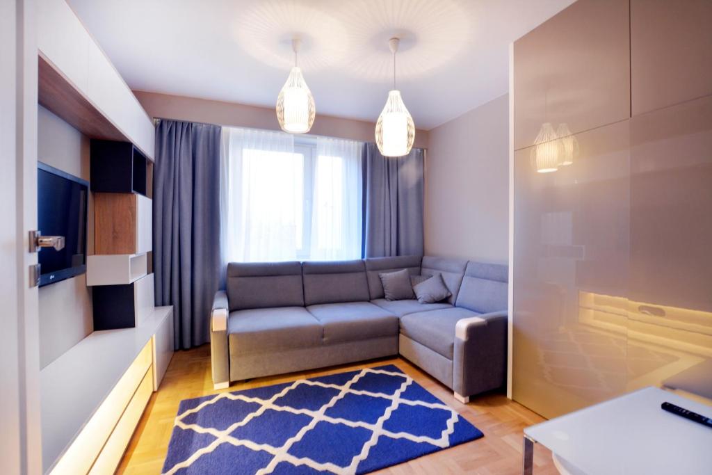 a living room with a couch and a rug at Apartamenty MIZU - "Marmur" in Kołobrzeg
