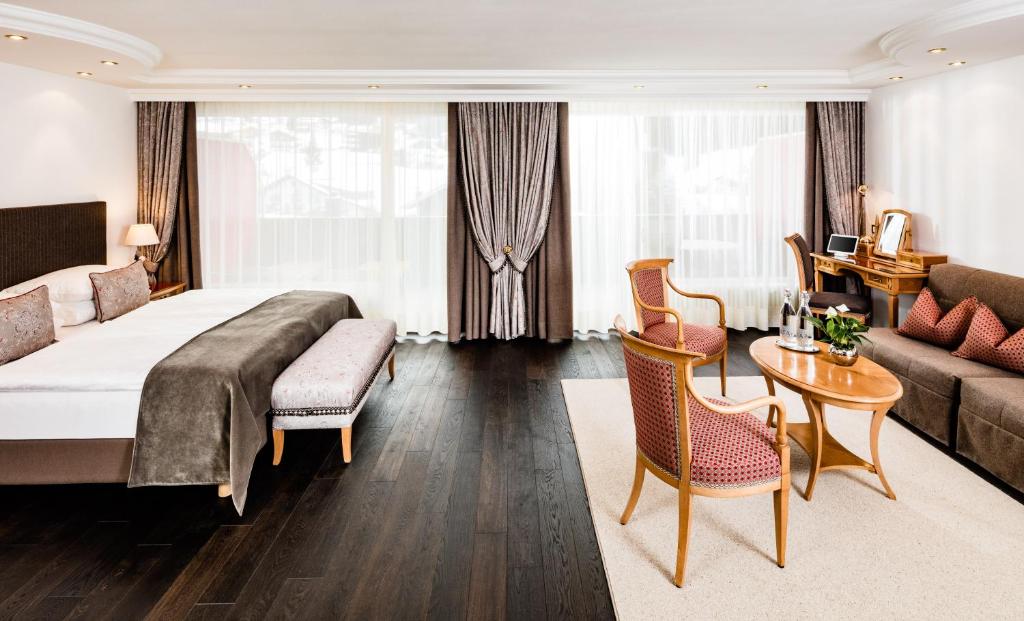 a hotel room with a bed and a living room at Hotel Alpenroyal - The Leading Hotels of the World in Selva di Val Gardena