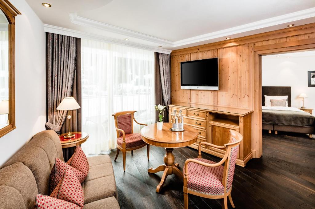 a living room with a couch and a table in a room at Hotel Alpenroyal - The Leading Hotels of the World in Selva di Val Gardena