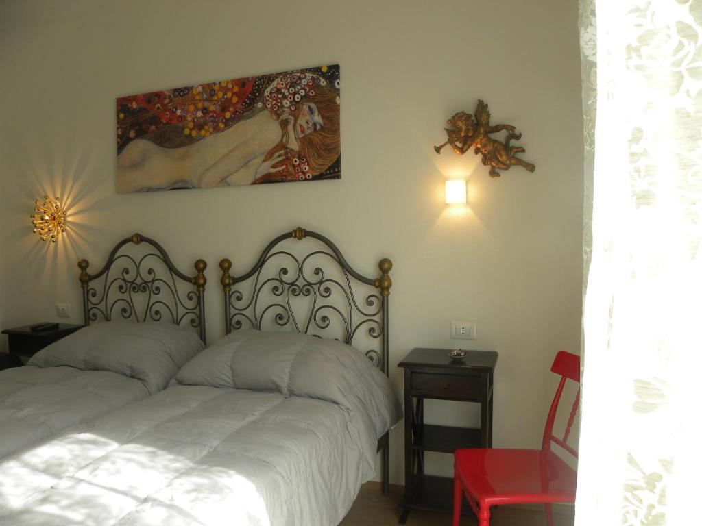 a bedroom with a bed and a painting on the wall at Corte Del Gallo in Corniglia