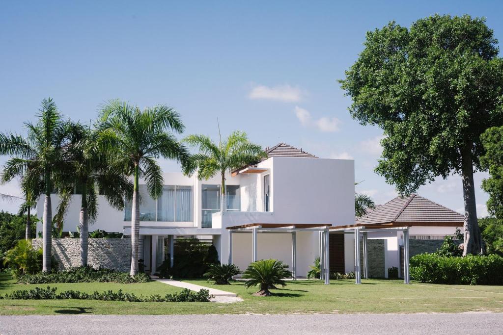 una casa blanca con palmeras delante en Villa "Bella Luna", en Punta Cana
