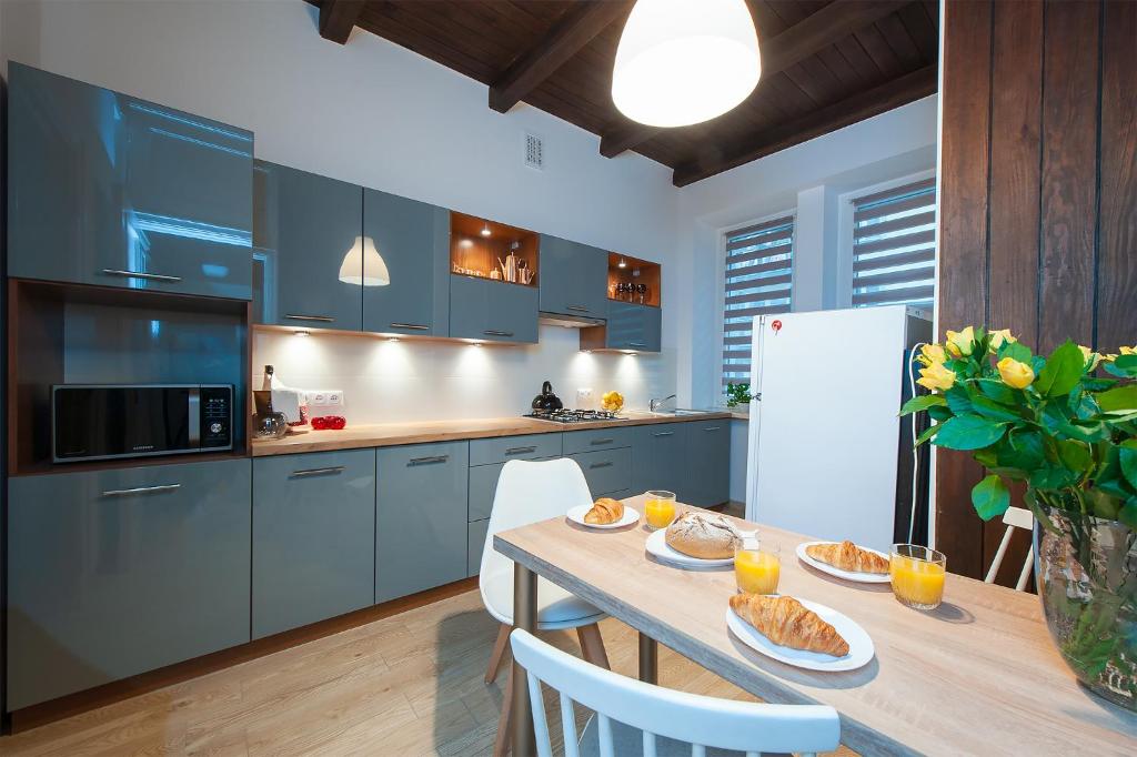 a kitchen with blue cabinets and a table with food on it at 4CULTURE APART bezpłatny parking in Łódź