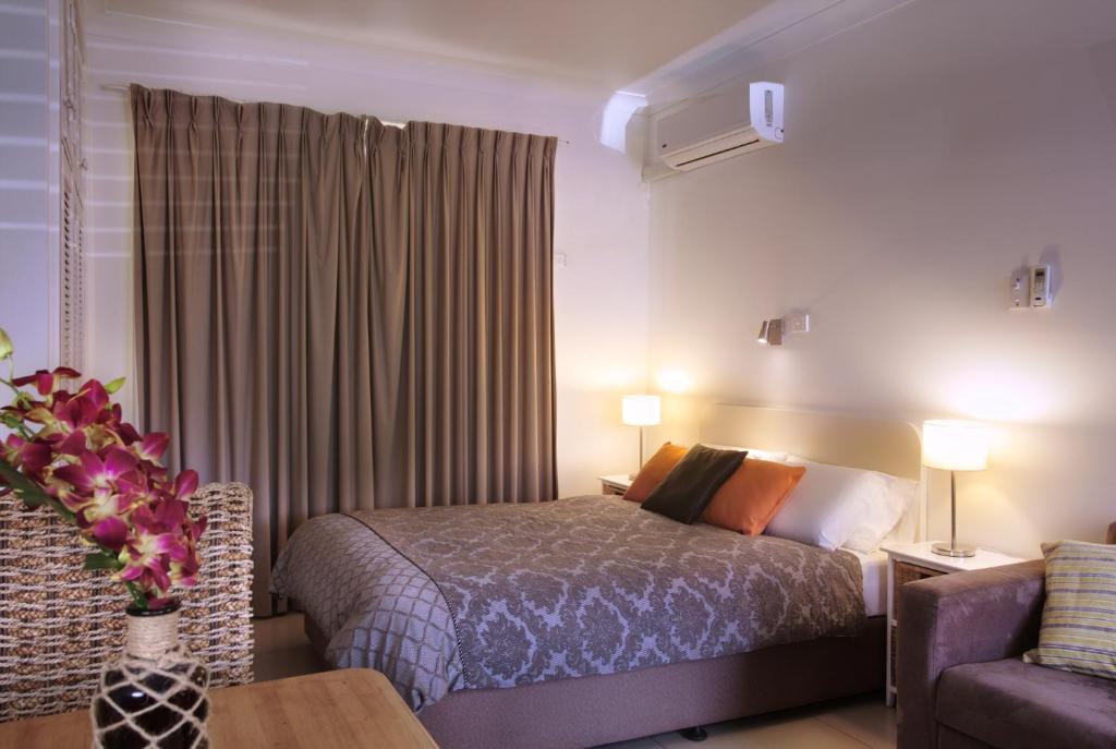 Habitación de hotel con cama y sofá en Tuncurry Motor Lodge en Tuncurry