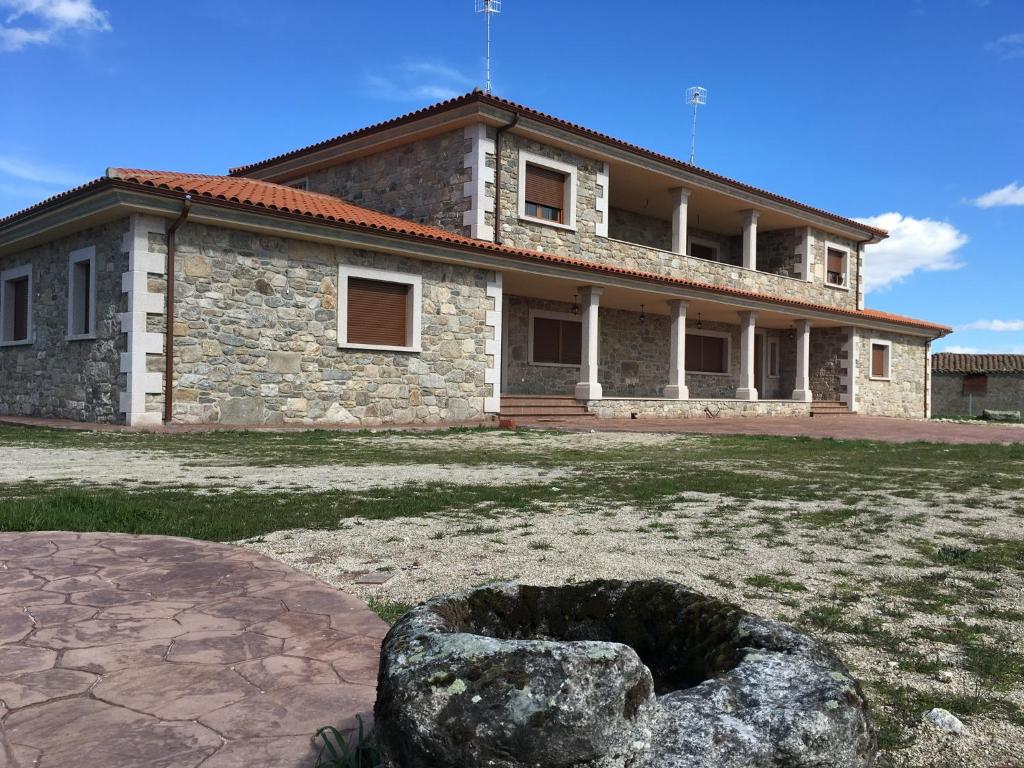a stone house with a large rock in front of it at Finca La Vega in Zamora