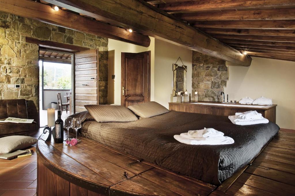 sypialnia z dużym łóżkiem i kamienną ścianą w obiekcie Borgo Casa al Vento w mieście Gaiole in Chianti