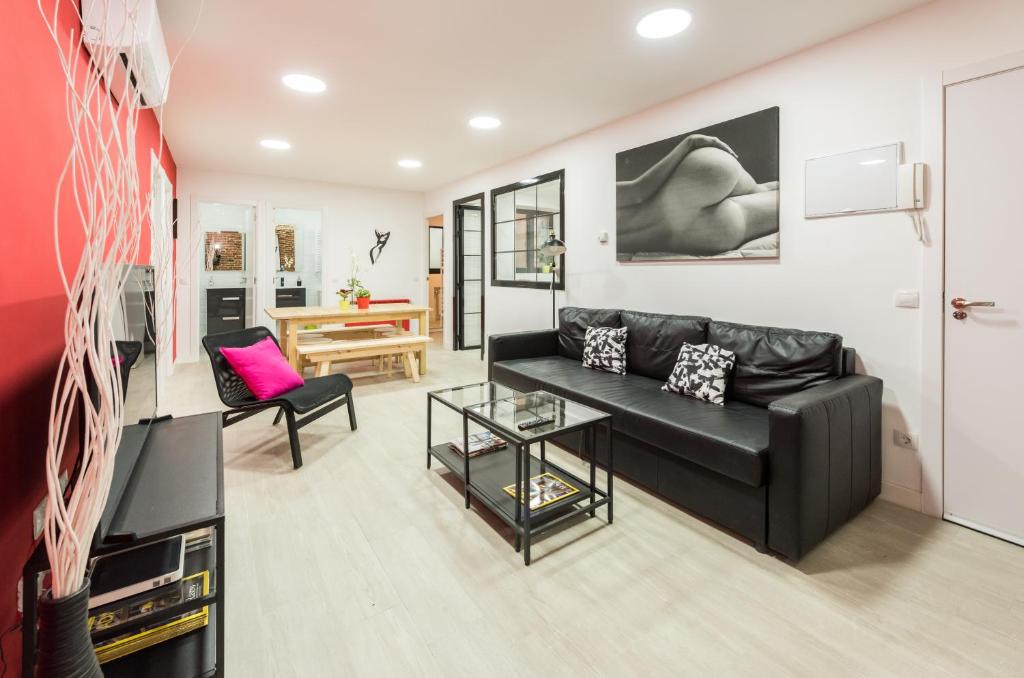 sala de estar con sofá de cuero negro en Ever House - ALCALA AIRE Gran TERRAZA ROOFTOP, en Madrid