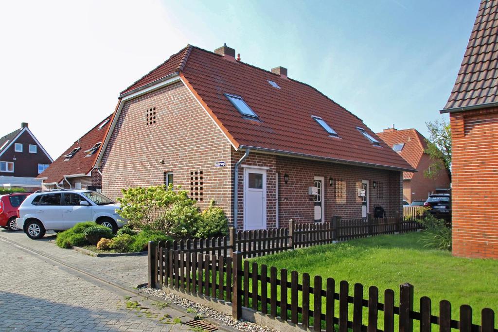 a brown brick house with a red roof at Fischerweg 5 in Norddeich