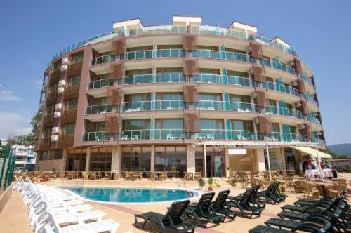 um grande edifício com cadeiras e uma piscina em frente em Briz Beach apartments - section B em Sunny Beach