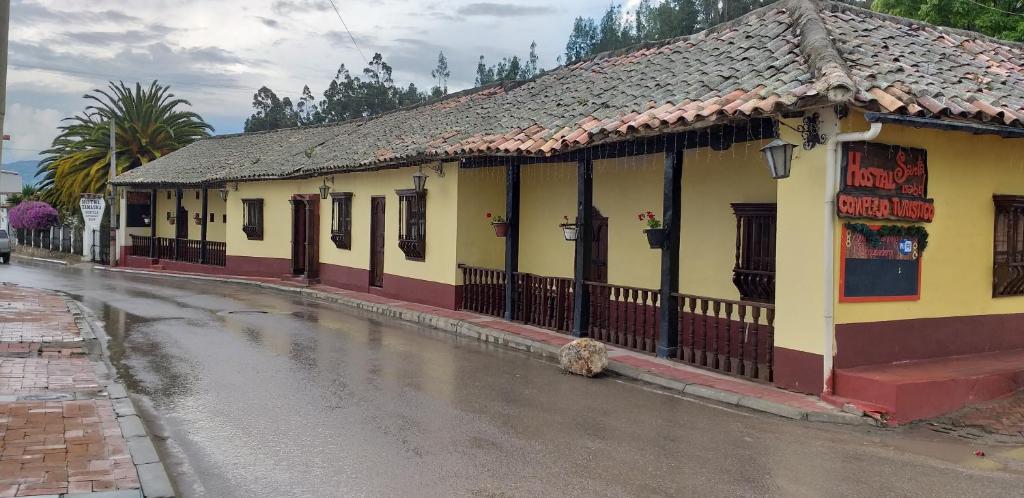 un bâtiment situé sur le côté d'une rue dans l'établissement Hostal ComplejoTurístico Santa Isabel, à Iza