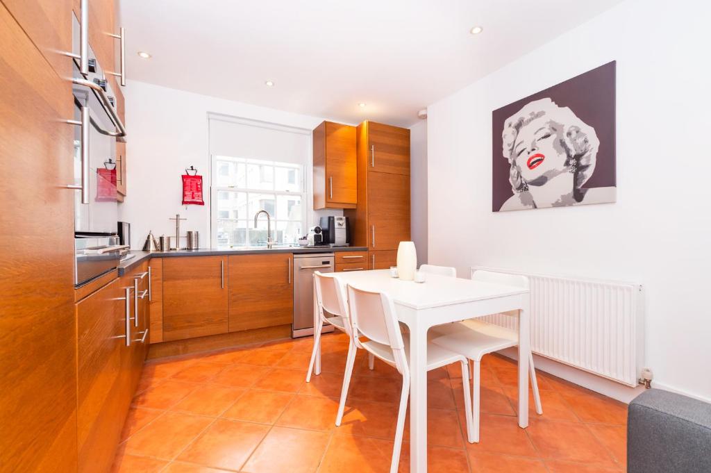 a kitchen with a white table and white chairs at New 2 Bed Apartment in Covent Garden in London