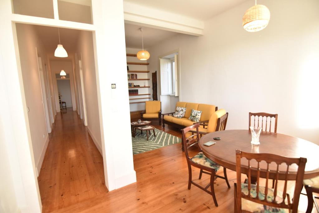 a dining room and living room with a table and chairs at Casa Pé da Cabra in Coimbra