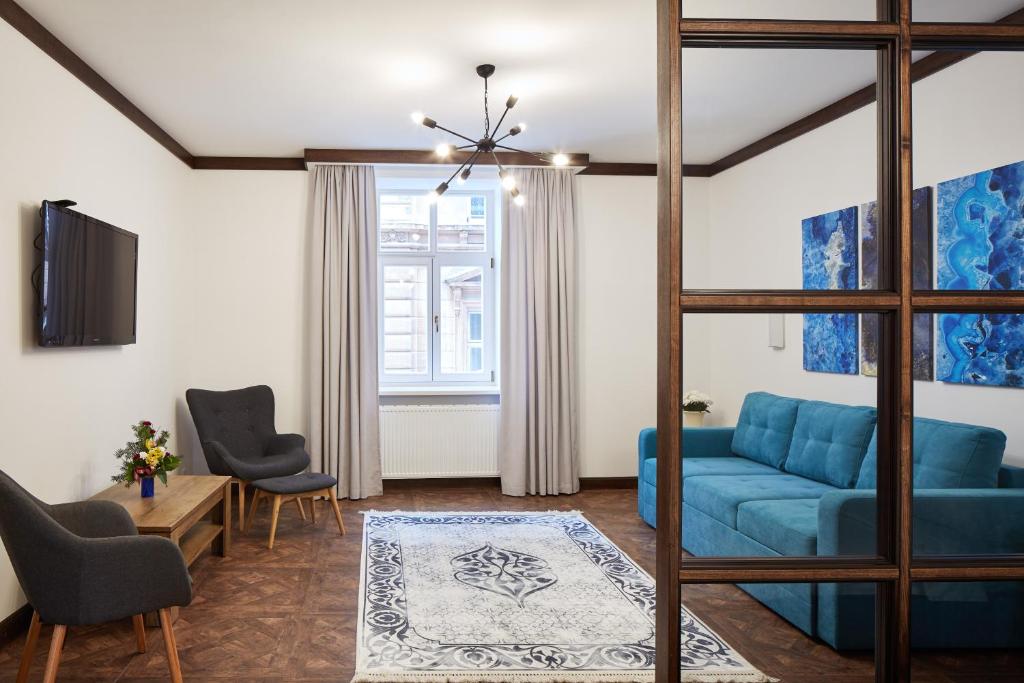 リヴィウにあるOld HOUSE apartmentのリビングルーム(青いソファ、椅子付)