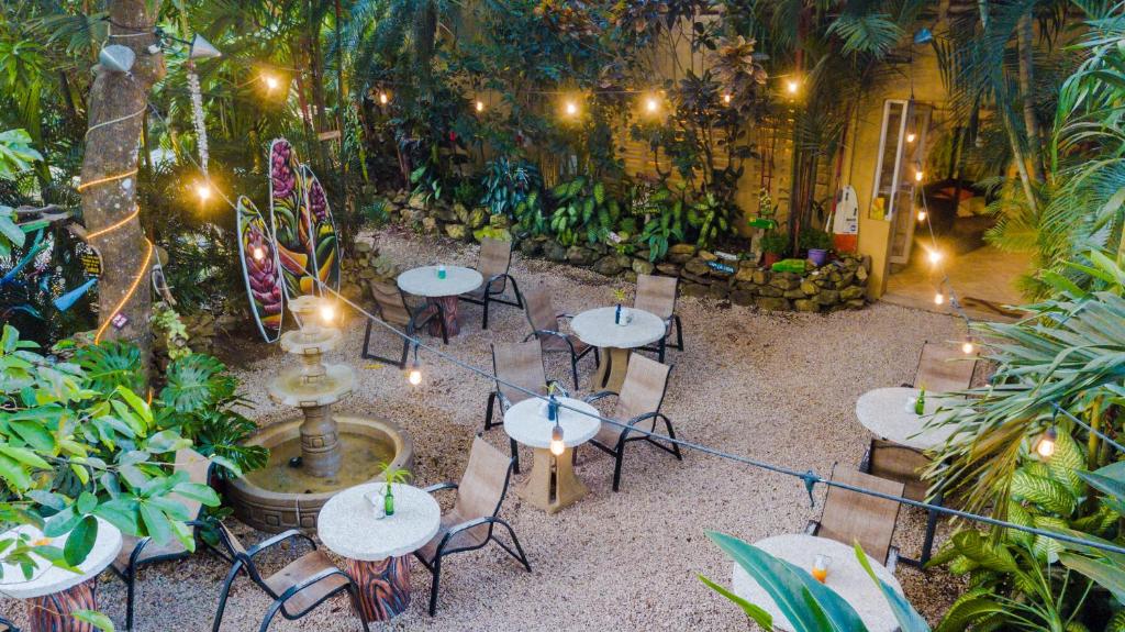 a restaurant with tables and chairs in a garden at El Sano Banano Beachside Hotel in Montezuma