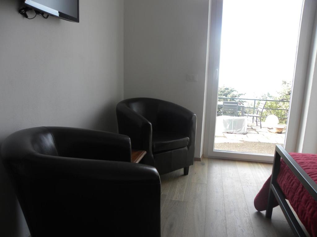 a living room with two chairs and a window at Corte Del Gallo in Corniglia