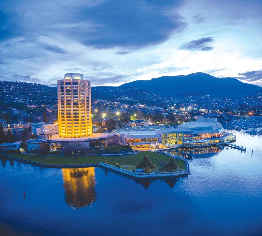 een stad met een groot gebouw in het water 's nachts bij Wrest Point in Hobart