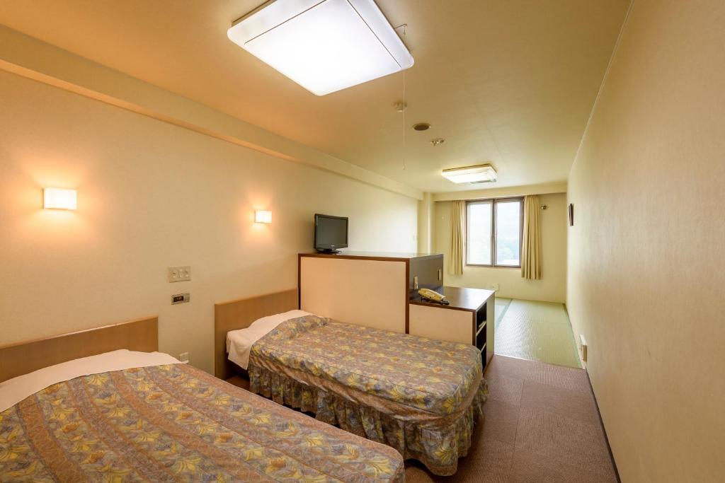 Postel nebo postele na pokoji v ubytování Hotel Tagawa