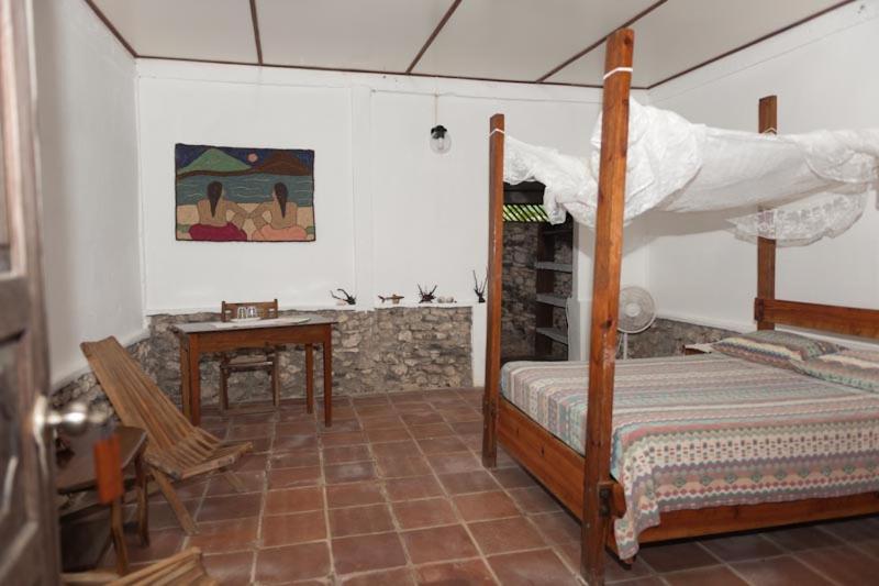 a bedroom with a bed and a table and a desk at La Princesa de La Isla in Big Corn Island