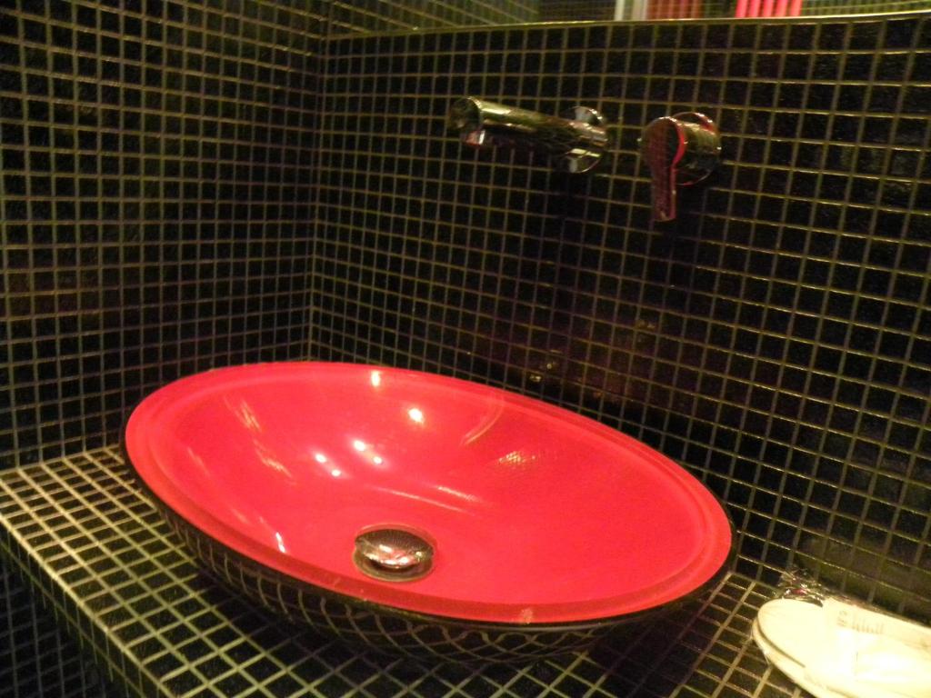 a red sink in a black tiled bathroom at Corte Del Gallo in Corniglia