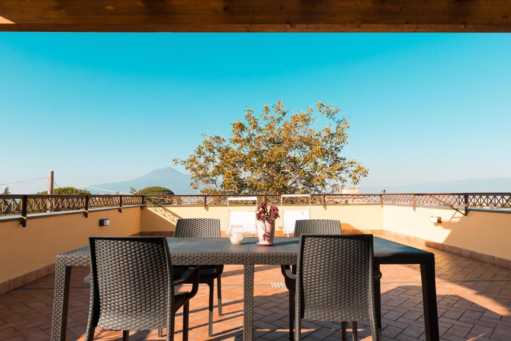 una mesa y sillas en un balcón con un árbol en Viale Villa Arianna, 8, en Castellammare di Stabia