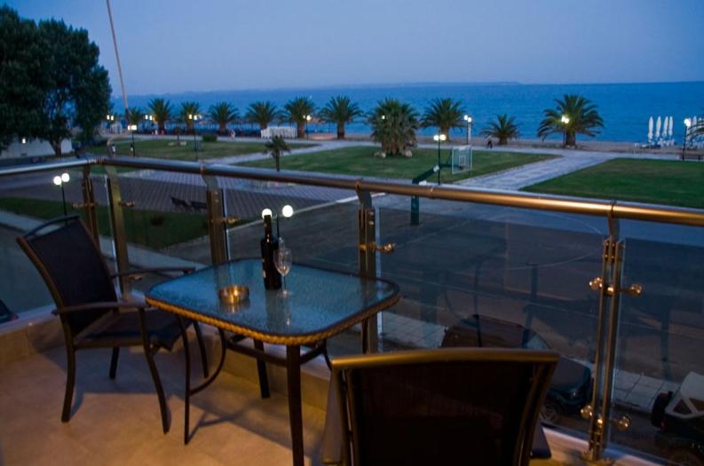 una mesa y sillas en un balcón con vistas al océano en Hotel Horizontas, en Nea Plagia