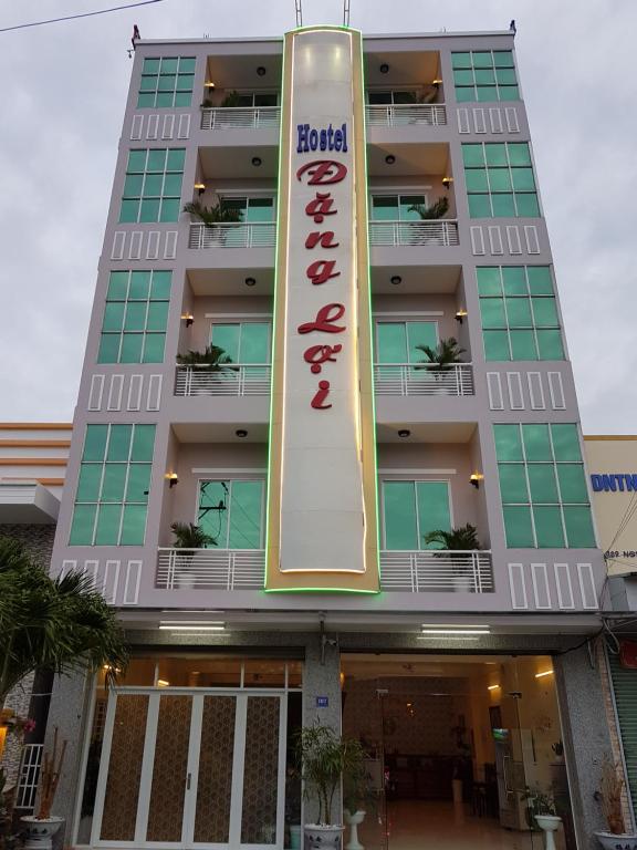 a building with a hotel sign in front of it at Hostel Đặng Lợi ホステルダンロイ in Chau Doc