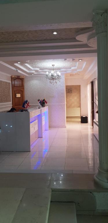 una grande camera con lampadario a braccio in un edificio di B&B Europa Hotel a Kutaisi