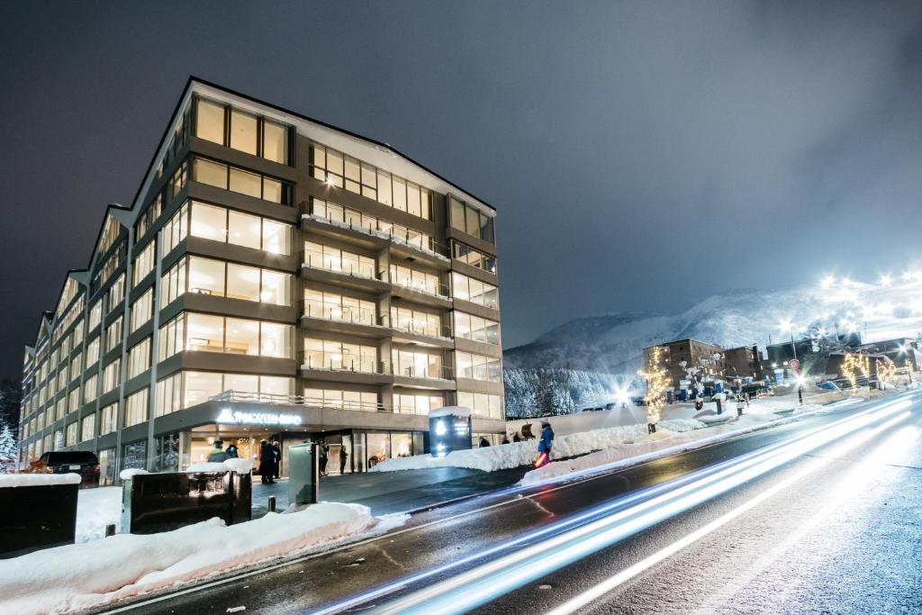 a building on the side of a street at night at The Maples Niseko in Niseko