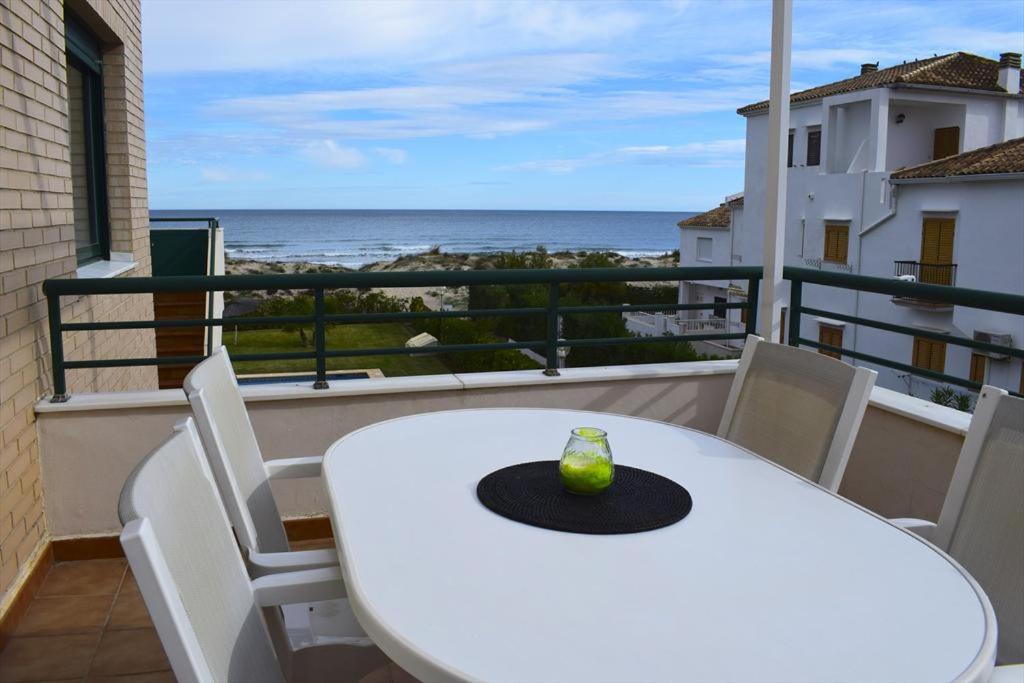 uma mesa branca e cadeiras numa varanda com o oceano em San Fernando Palace AT711 em Oliva