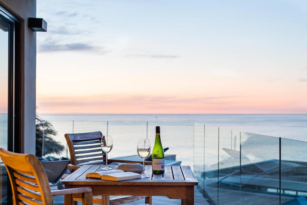 a table with a bottle of wine and two glasses at Lions Eye Luxury Apartments in Cape Town