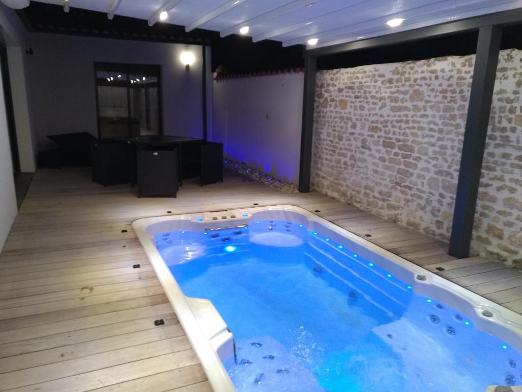 a large swimming pool in a room with a wooden floor at Océan d'amour & spa in Saint-Vivien