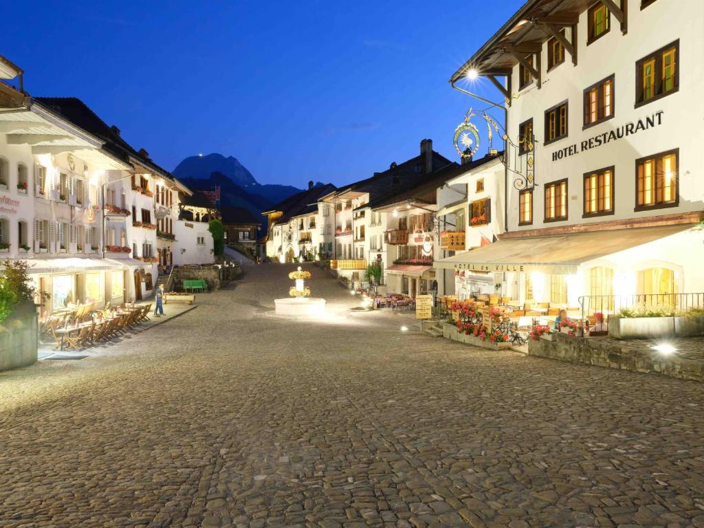 a street in a town at night with buildings at Hôtel de Ville in Gruyères