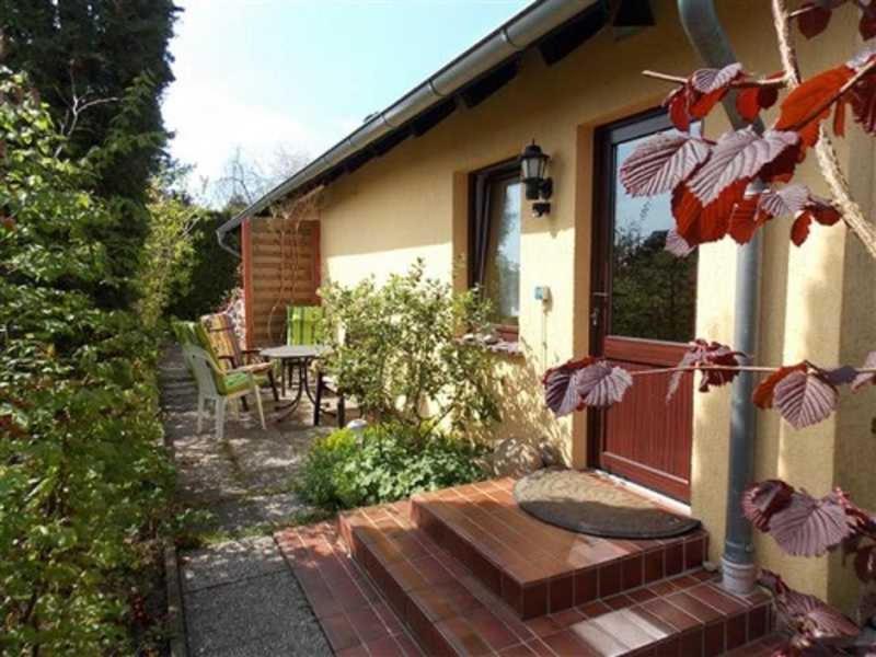 ein Haus mit einer Terrasse mit einem Tisch und einem Fenster in der Unterkunft Ferienappartements Haus Fischersruh in Lauterbach