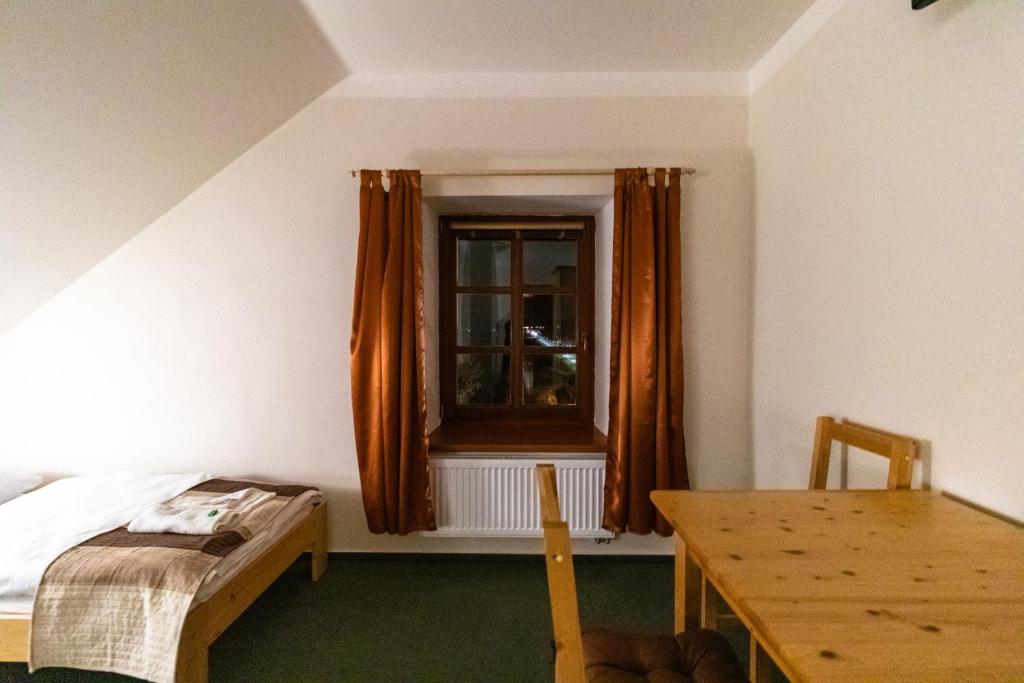 a bedroom with a bed and a window and a table at Penzion U řízků in Rapotín