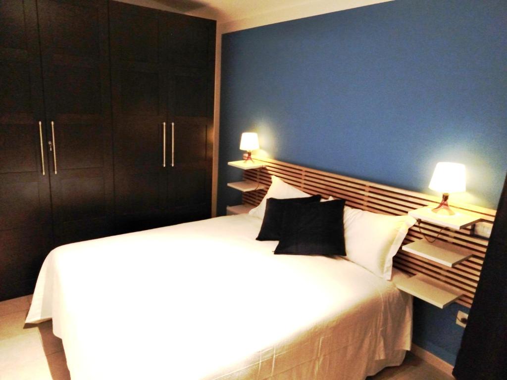 1 dormitorio con 1 cama blanca grande y pared azul en Acetylene B&B en Rapolano Terme