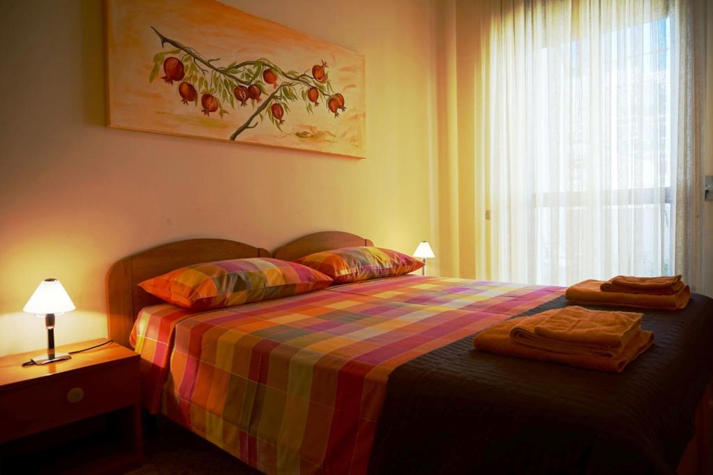 a bedroom with a bed with a colorful blanket and a window at B&B Piazza 300mila in Lecce