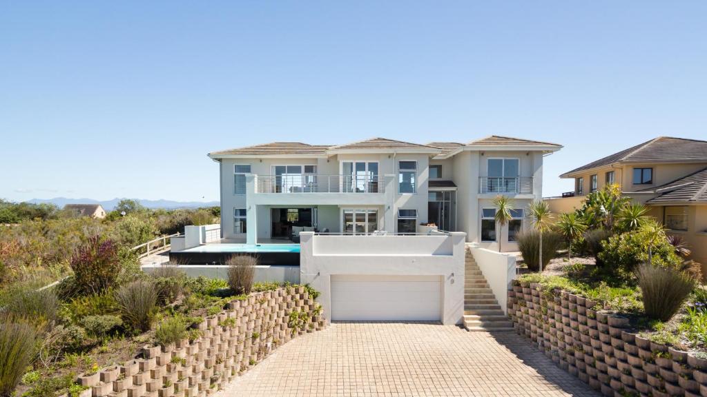 a house with a gate in front of a driveway at Pezula Double Storey Luxury in Knysna