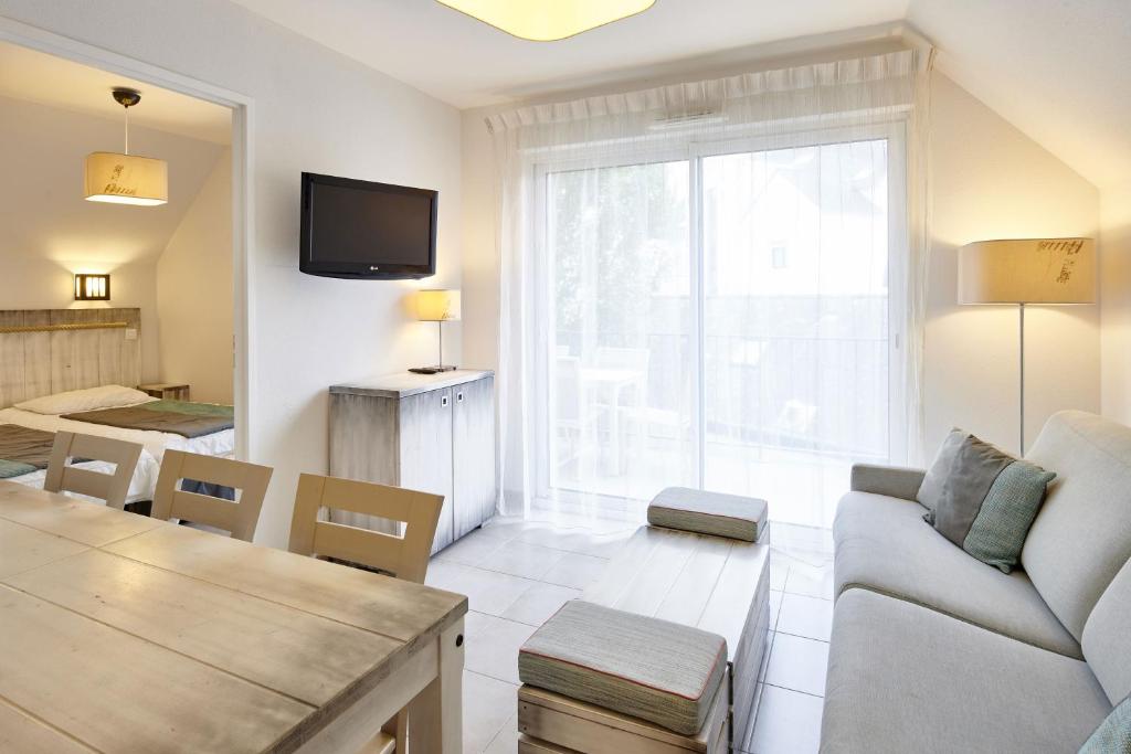 a living room with a couch and a table at Résidence Vacances Bleues Les Jardins d'Arvor in Bénodet
