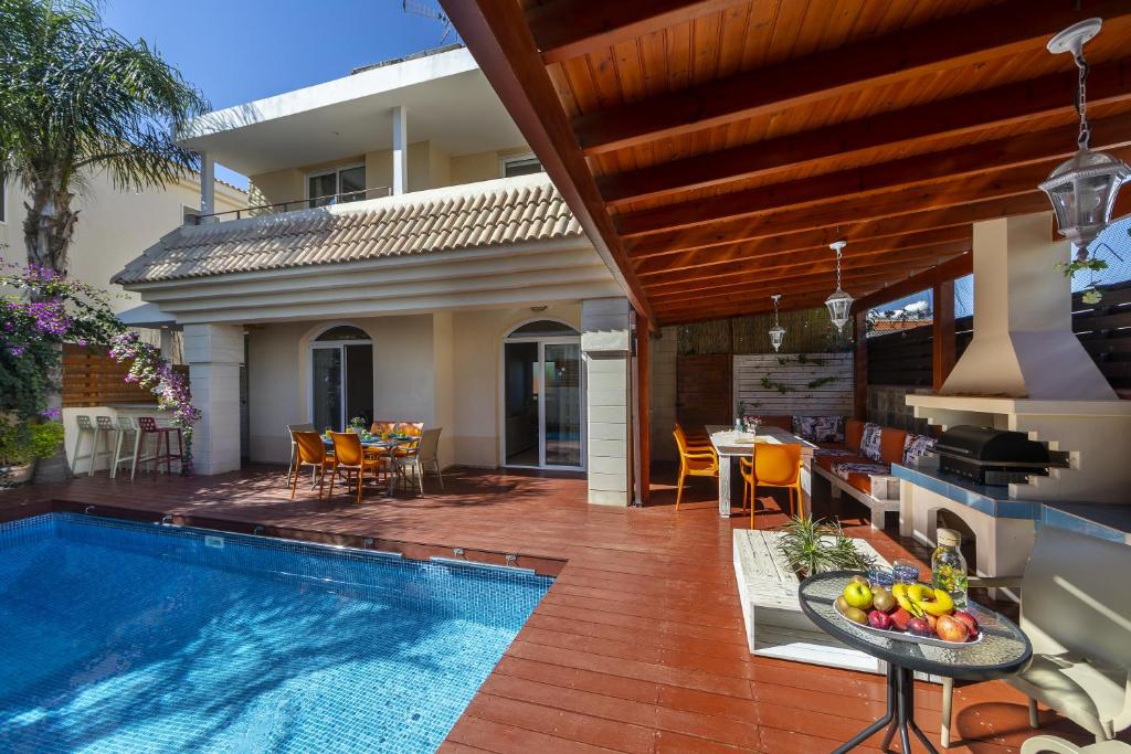 une maison avec une piscine et un coin repas dans l'établissement Protaras Villa Rocco, à Paralímni