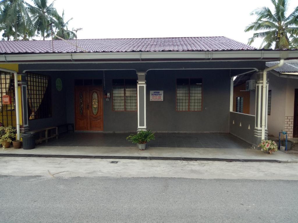 a blue building with a door and a porch at Aiman Homestay in Marang