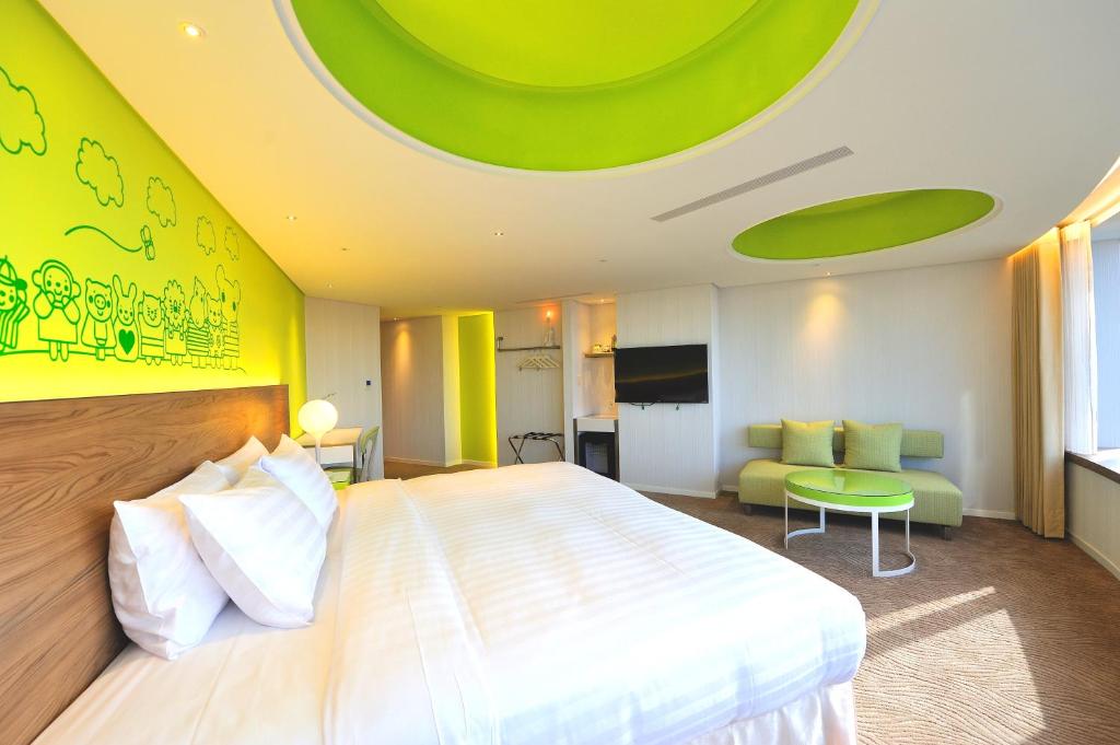 a bedroom with a large bed and a green ceiling at Green World Hotel - Zhonghua in Taipei