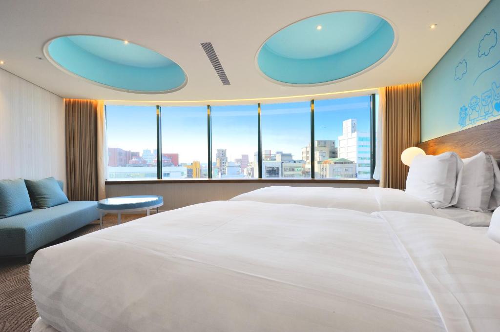 a hotel room with two beds and a large window at Green World Hotel - Zhonghua in Taipei