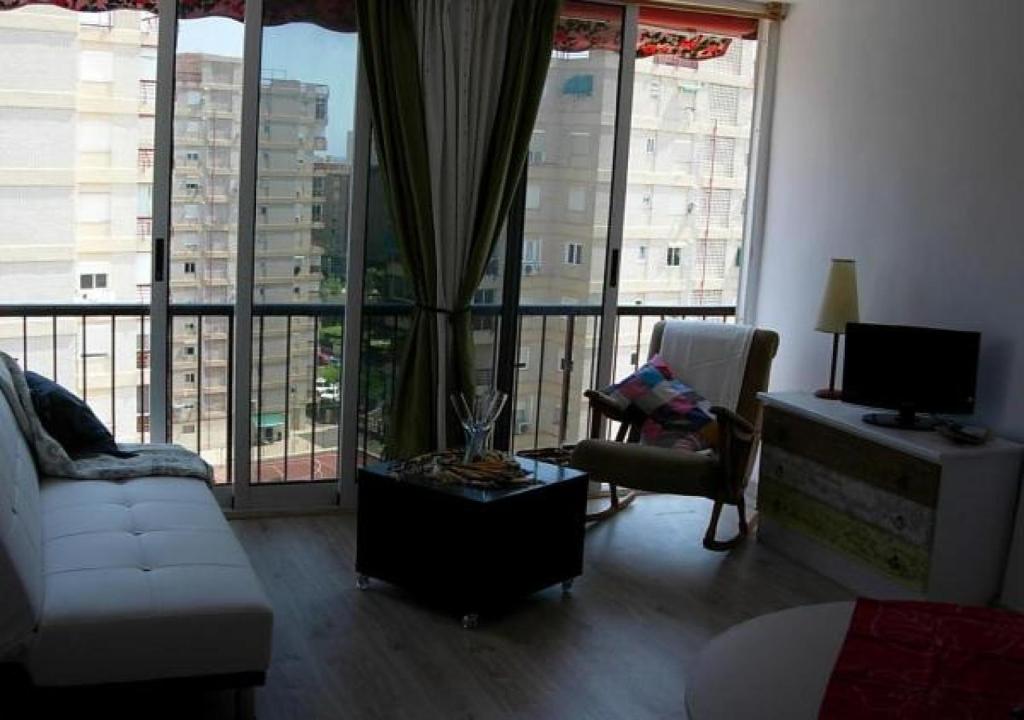 a living room with a white couch and a tv and large windows at Calablu in Alicante